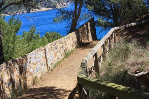 a path with a fence next to the water at Casa Mediterránia de Palamós amb piscina privada in Palamós