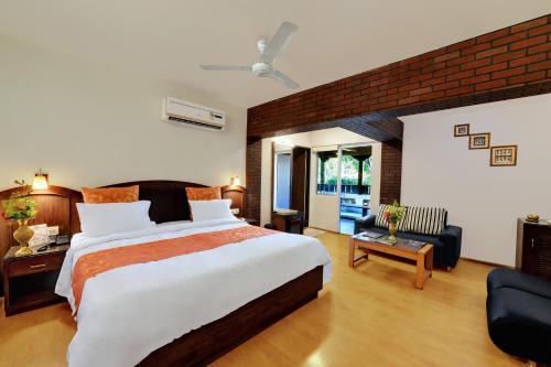 a bedroom with a large bed and a living room at Chacha Inn The Garden Retreat in Mount Ābu