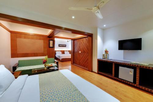 a hotel room with a bed and a television at Chacha Inn The Garden Retreat in Mount Ābu