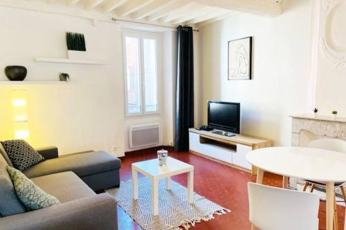 een woonkamer met een bank en een tafel bij Appartement situé Place des Arcades à Biot à 4 min de la mer et des plages in Biot
