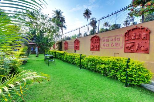 a garden with red signs on the side of a building at Chacha Inn The Garden Retreat in Mount Ābu