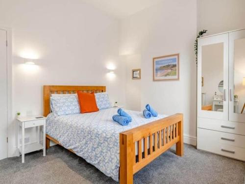 a bedroom with a bed with blue pillows on it at Seagull Escapes - short walk to the beach in Scarborough