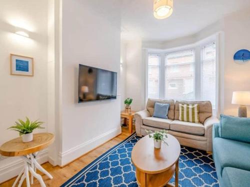 a living room with a couch and a table at Seagull Escapes - short walk to the beach in Scarborough