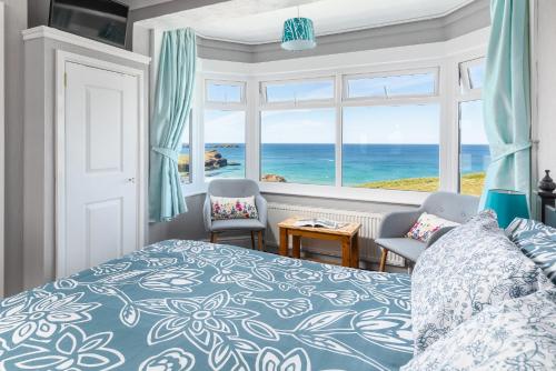 a bedroom with a bed and a view of the ocean at Kenton in Newquay