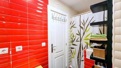 a bathroom with a red accent wall and a door at Los Caños - Parking opcional in Jaén