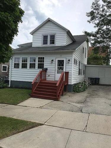 a white house with a wooden ramp in front of it at Serene Home One Block From Lake Michigan in Sheboygan