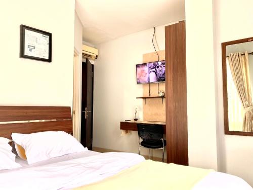 a bedroom with a bed and a desk in it at Behomy Corner 8 Lippo Karawaci in Tangerang