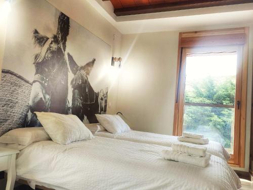a bedroom with a bed with towels on it at Casa Rural A Ritmo De Burro in Robledondo