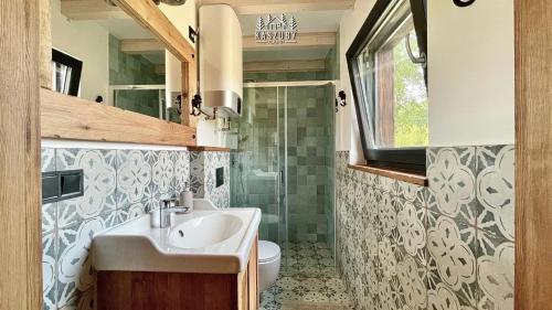 ein Bad mit einem Waschbecken und einem WC in der Unterkunft Kaszuby Camp in Barkocin