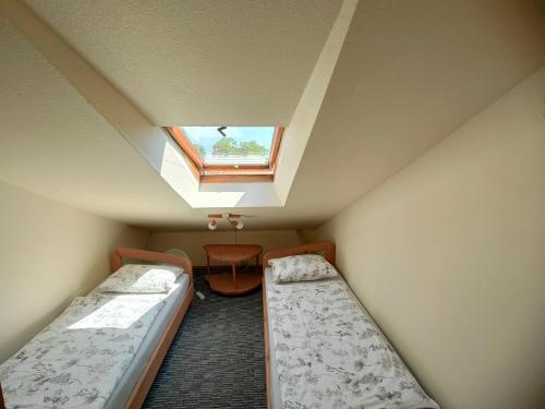 Ce dortoir comprend 2 lits et une lucarne. dans l'établissement Aušras Mansarde, à Nido