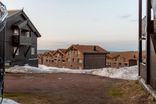 a parking lot in front of a group of buildings at Høyfjellsgrend 961, 29 B in Trysil