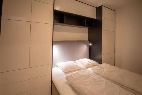 um pequeno quarto com uma cama e um closet em Høyfjellsgrend 961, 29 B em Trysil