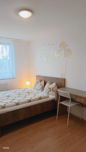 a bedroom with a bed and a desk and a chair at HOKE lakás in Sopron