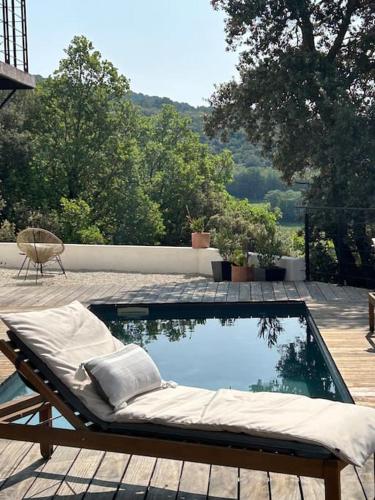 - un lit à côté de la piscine dans l'établissement Belle maison contemporaine, à Ampus