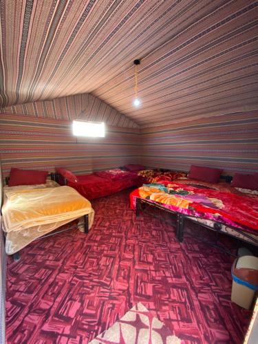 two beds in a room with a purple ceiling at Wadi Rum Bedouin Heart Camp in Wadi Rum