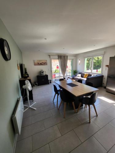 uma sala de estar com uma mesa e um sofá em Appartement vue mer em Saint-Georges-de-Didonne