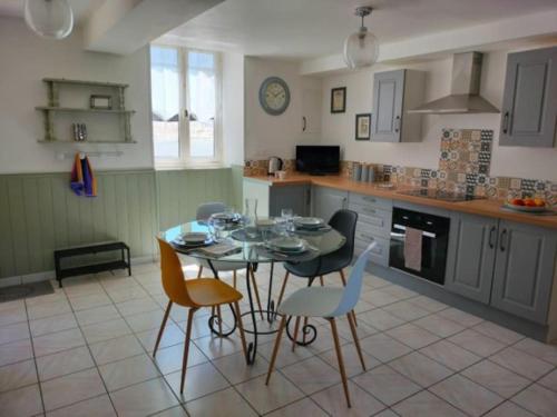 a kitchen with a table and chairs in a room at Gîte privatif, proche nature et plan d'eau in Charlanges