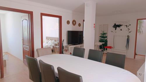 a dining room with a white table and chairs at HOKE lakás in Sopron