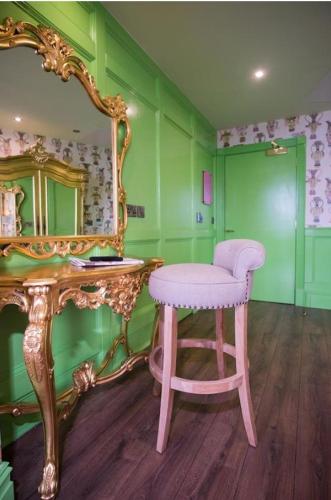 a pink stool in a room with a mirror at The Shankly Hotel in Liverpool