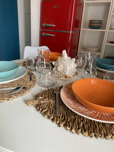 una mesa con platos y vasos y una nevera roja en Casa Vacanze Nene, en Minturno