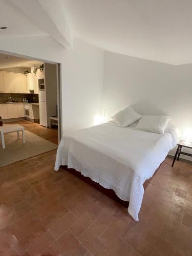 Cet appartement comprend une chambre avec un lit blanc et une cuisine. dans l'établissement SG Apartamento céntrico ático, à Terrassa