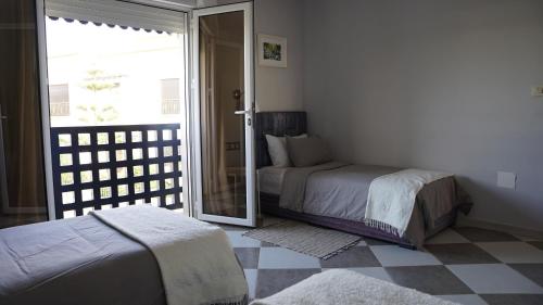 a bedroom with two beds and a sliding glass door at riad casa bahia asilah in Asilah