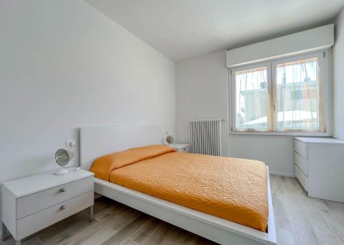 una camera bianca con un letto e una finestra di Nuovo Bilocale con posto auto a Varazze