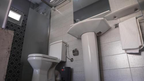 a bathroom with a white toilet and a sink at riad casa bahia asilah in Asilah
