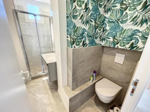 La salle de bains est pourvue de toilettes et d'un mur orné de plantes. dans l'établissement 1 bedroom Palais Hoche Cannes 5 mins from the Croisette Cannes Riviera 226, à Cannes