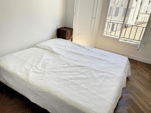 un lit blanc dans une chambre avec une fenêtre dans l'établissement 1 bedroom Palais Hoche Cannes 5 mins from the Croisette Cannes Riviera 226, à Cannes
