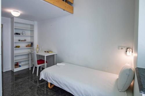 ein weißes Schlafzimmer mit einem Bett und einem Schreibtisch in der Unterkunft LightBox Central in Ljubljana
