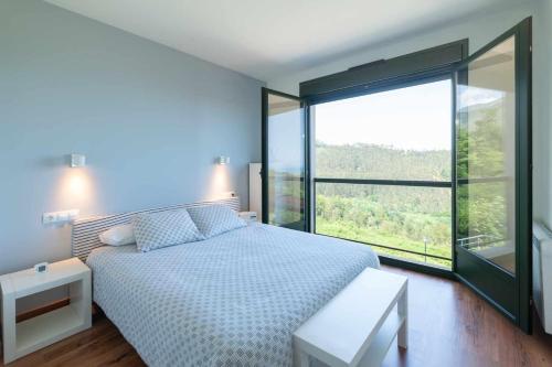a bedroom with a bed and a large window at Casa vacacional Ris in Duyos