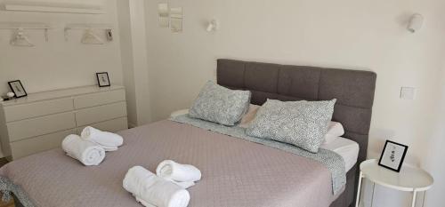 a bedroom with a bed with towels on it at Gemini Apartments in Kaštela