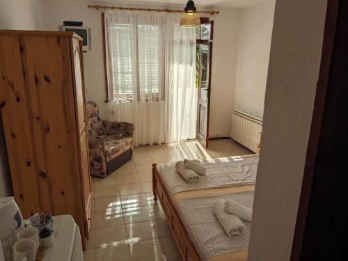 una sala de estar con 2 camas y una silla en Цвета en Sinemorets