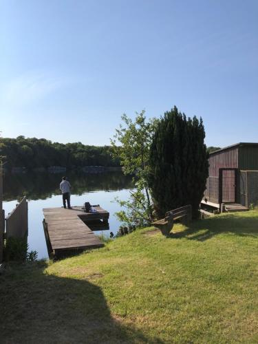 a man standing on a dock on a lake at In der Mühlenstraße in Malchow