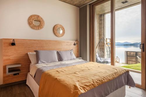 a bedroom with a bed and a large window at Wa One Lake Homes in San Carlos de Bariloche