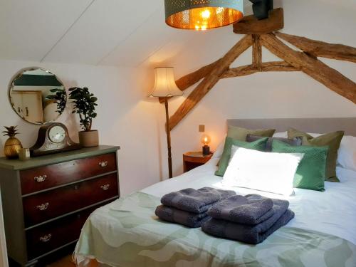 une chambre avec un lit avec des serviettes bleues dessus dans l'établissement Rusty Shears46 Eclectic couples escape, hot tub & Cahors vineyards, à Lacapelle-Cabanac