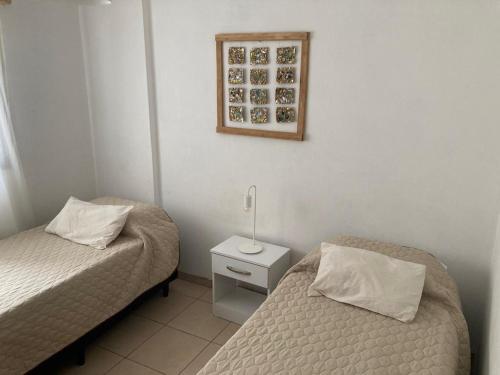 1 dormitorio con 2 camas y una foto en la pared en Pacífico Il en Córdoba