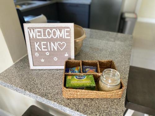 a basket on a counter with a welcome keeper sign at Serenity Get Away in Lucea