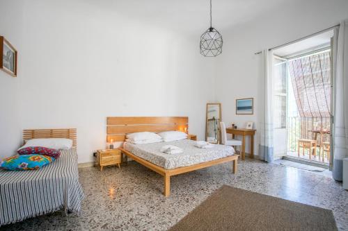 una camera con due letti e una grande finestra di Casa Maravì a Catania