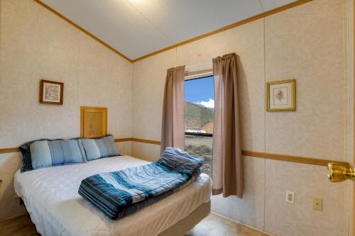 Schlafzimmer mit einem Bett vor einem Fenster in der Unterkunft Thousand Trails Blue Mesa Recreational Ranch in Hierro