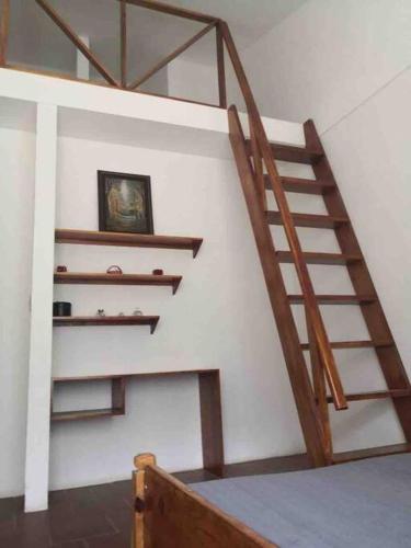 a wooden staircase in a white room with a picture at Casa Dulce Nombre in La Garita