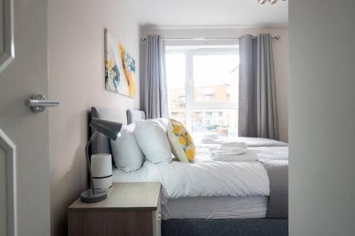 um quarto de hotel com uma cama e uma janela em Century Central, Cardiff Bay, Modern Chic 2BR, Free Parking em Cardiff