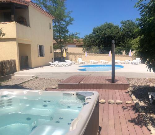 - un bain à remous dans une cour à côté d'une piscine dans l'établissement Gîte Canoé Piscine chauffée et Spa en Ardèche Méridionale, à Ruoms