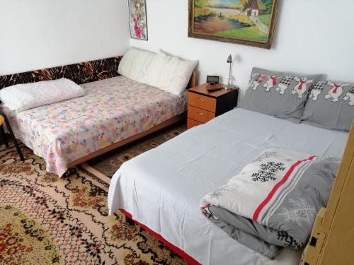 a bedroom with two beds and a dresser and a bedskirts at Rustic house in Turnu Măgurele
