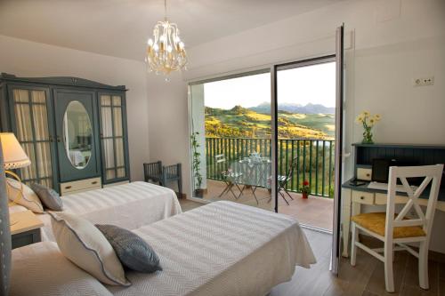 a bedroom with two beds and a balcony at Villa Cultural MONTELUCÍA in Montecorto