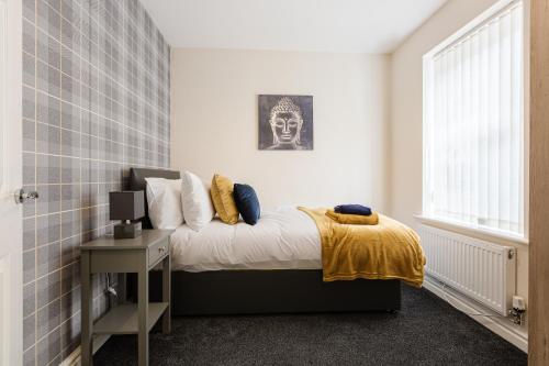 a bedroom with a bed with a skull picture on the wall at Oxheys House - 5 Bedrooms Contractors Parking in Preston