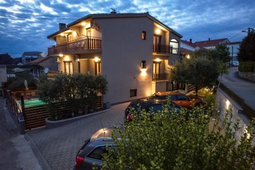 a building with two cars parked in front of it at Pool Apartments Julia in Zadar