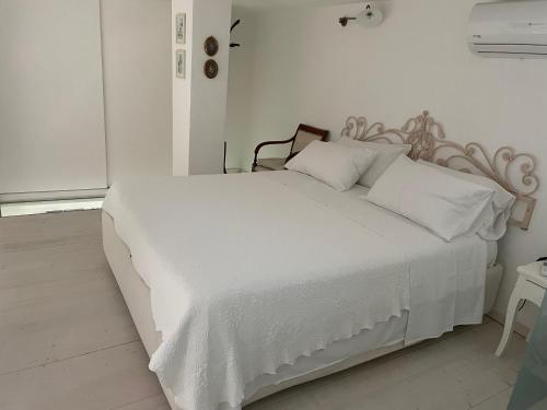a white bed with white sheets and pillows at Dimora Sorrento in Sant'Agnello