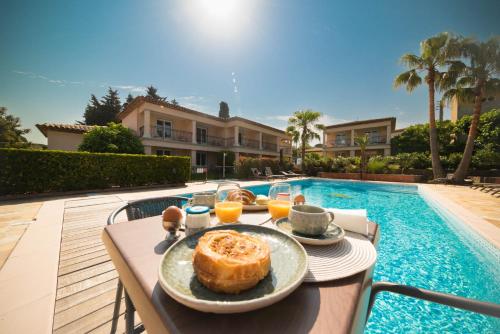 a plate of food on a table next to a pool at Hotel Brin d'Azur - Saint Tropez in Saint-Tropez